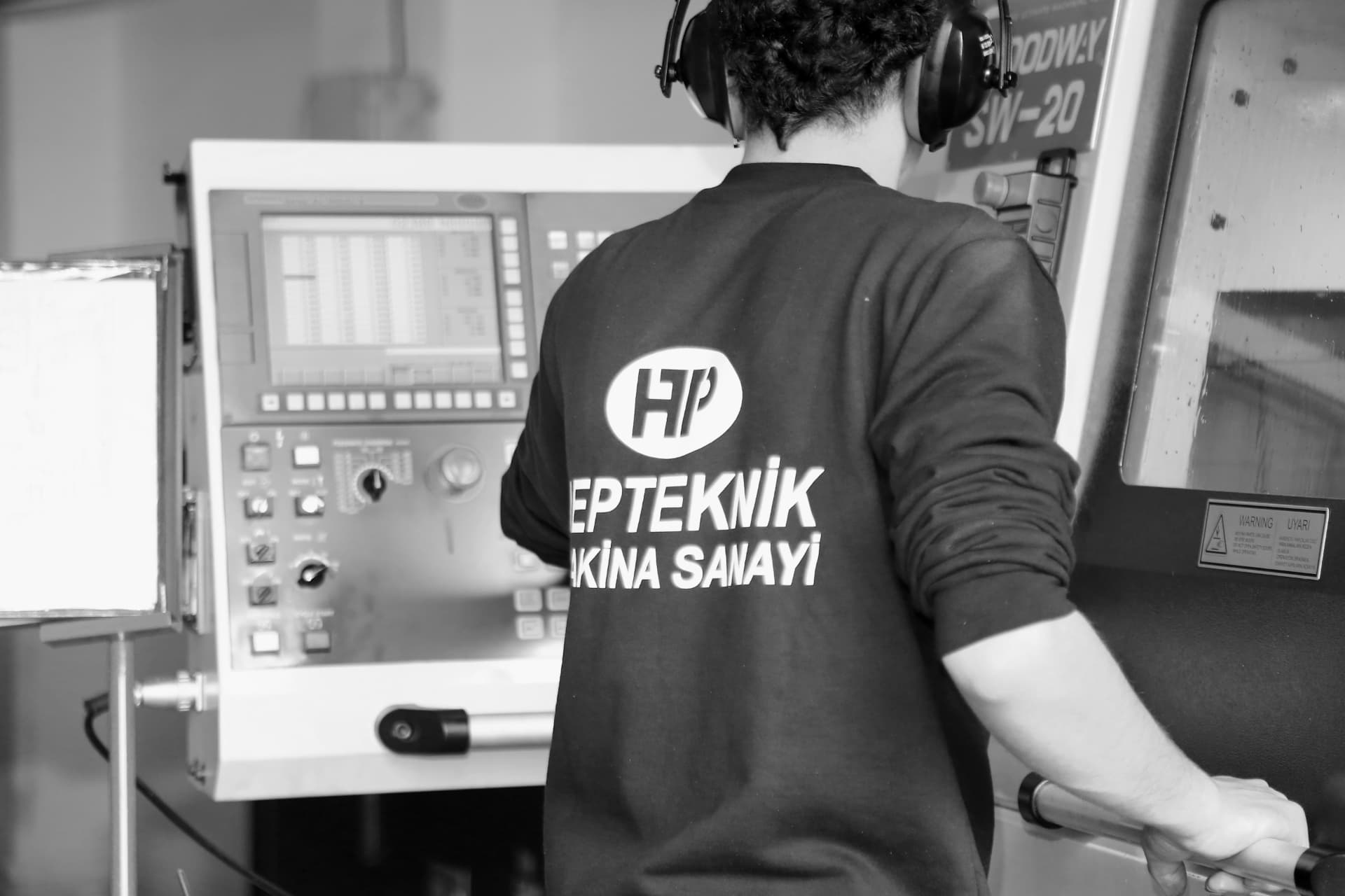 HEPTEKNIK operator running a Swiss-type sliding-head CNC machine